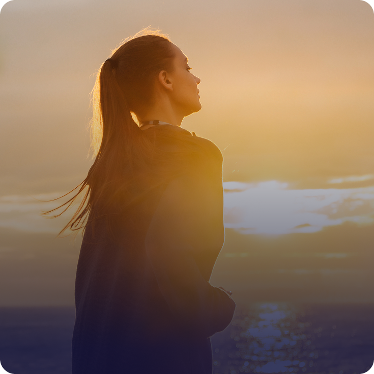 Woman looking up at the sky at sunset